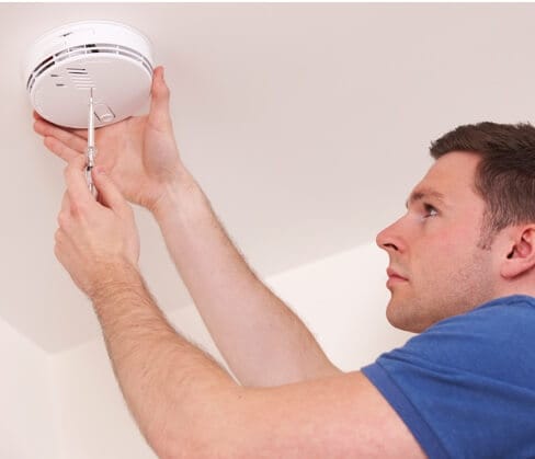 ADT home security technician installing smoke detector