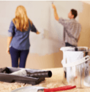 Couple painting interior home wall