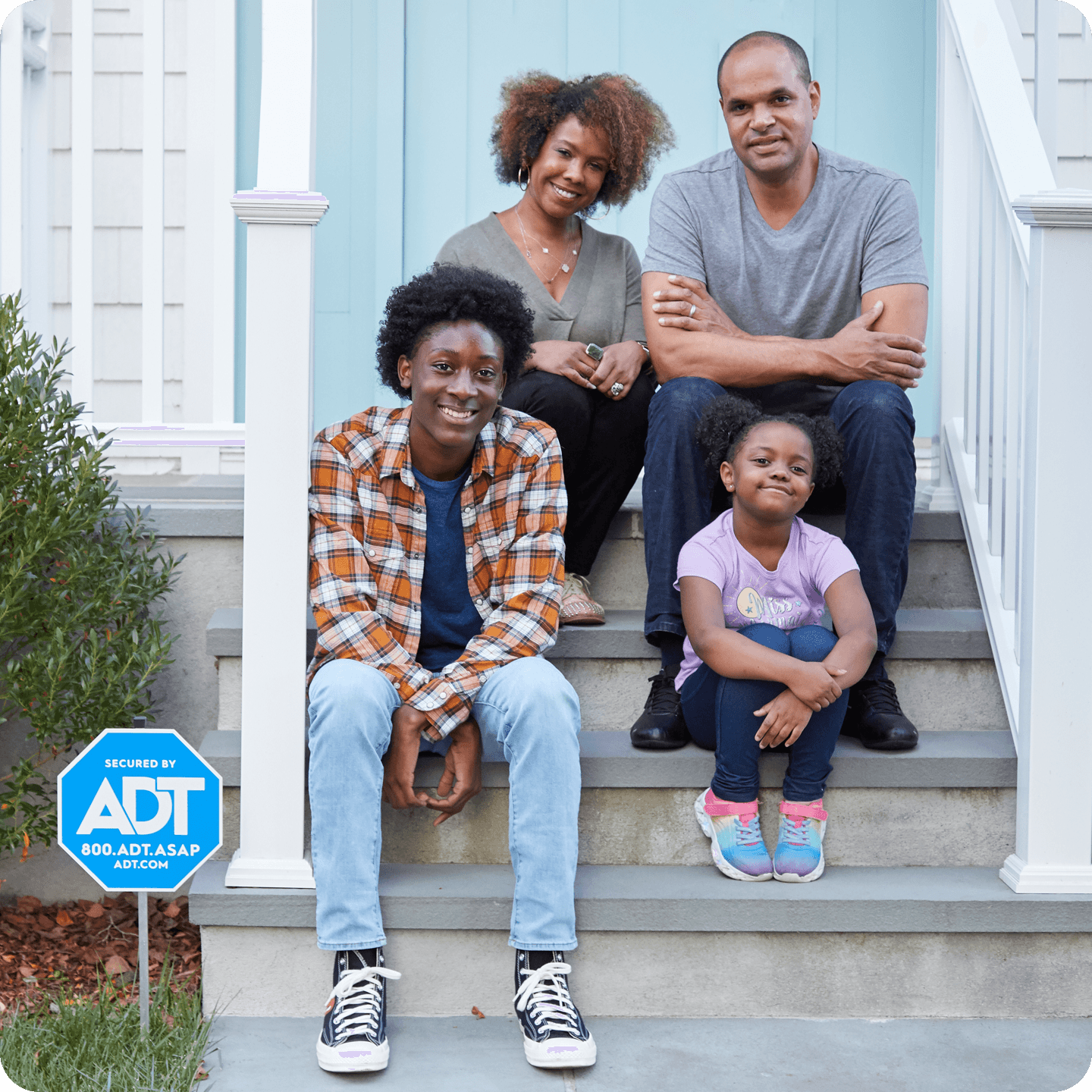 A family sits on front porch and smiles