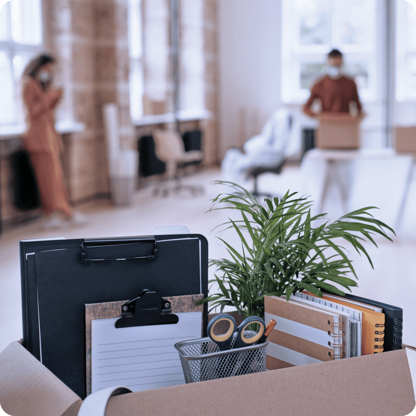 A group of workers move office supplies in boxes