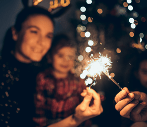 woman and child holding firework sparkler